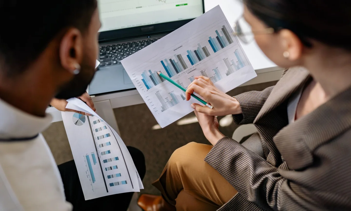 Two colleagues discussing printed graphs