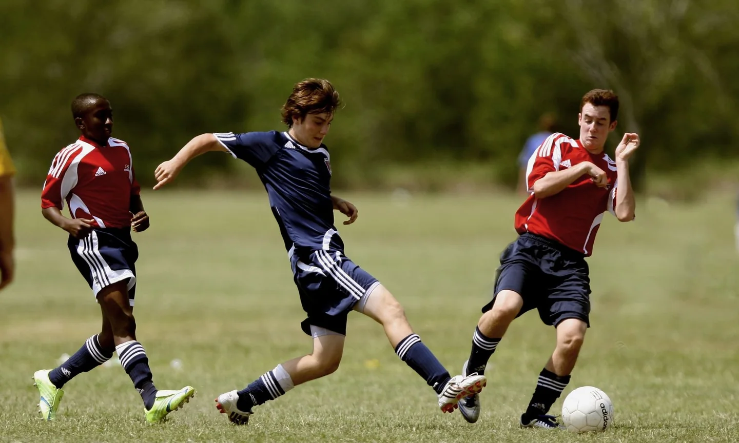 Football players competing for the ball during an outdoor match