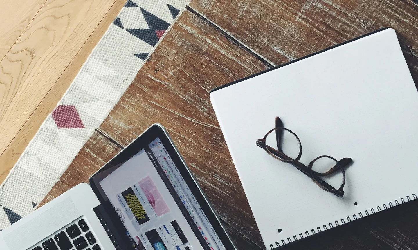 Planning desk with a notebook, laptop and phone