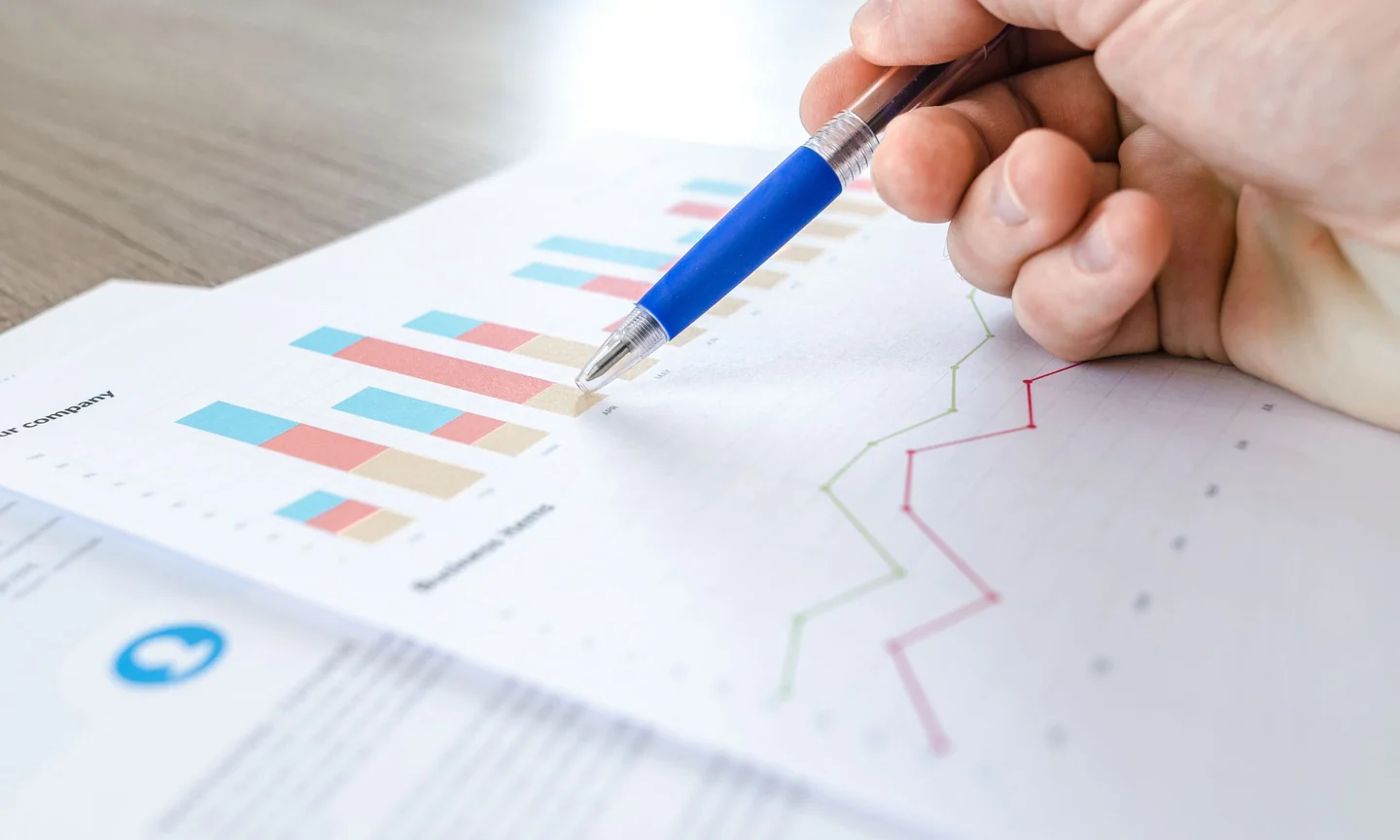 Hands reviewing printed charts with a pen