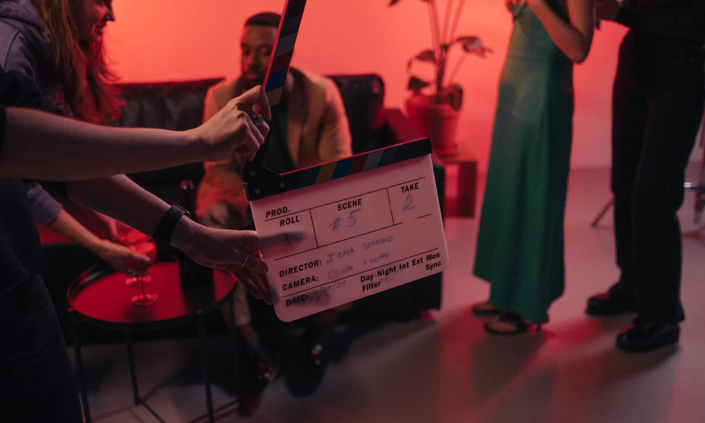 Film crew checking a clapperboard on a red-lit set